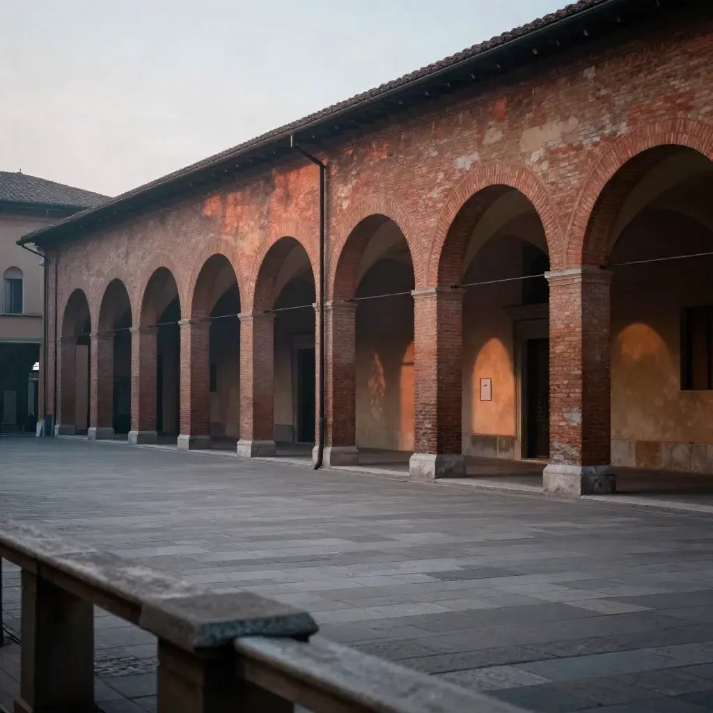 Portici di Bologna al crepuscolo sopra una piazza di pietra vuota e nebbia leggera